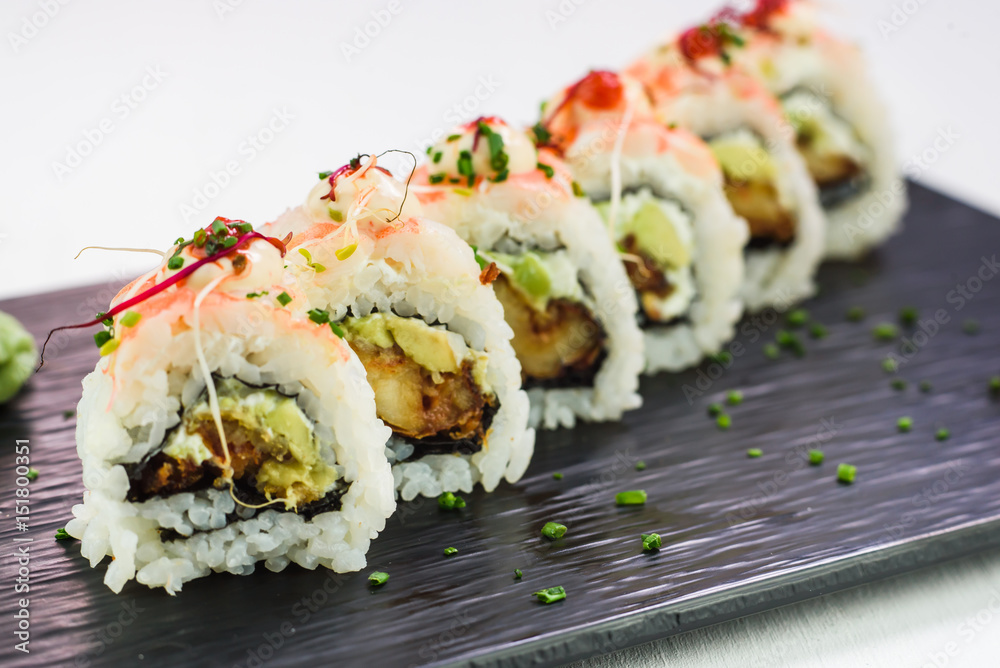 Japanese traditional rolls and sushi on a black stone plate Japanese traditional rolls and sushi on a black stone plate