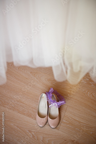 Bride's shoes under a wedding dress