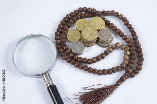 Rosary and coins on white background. Islamic business concept.