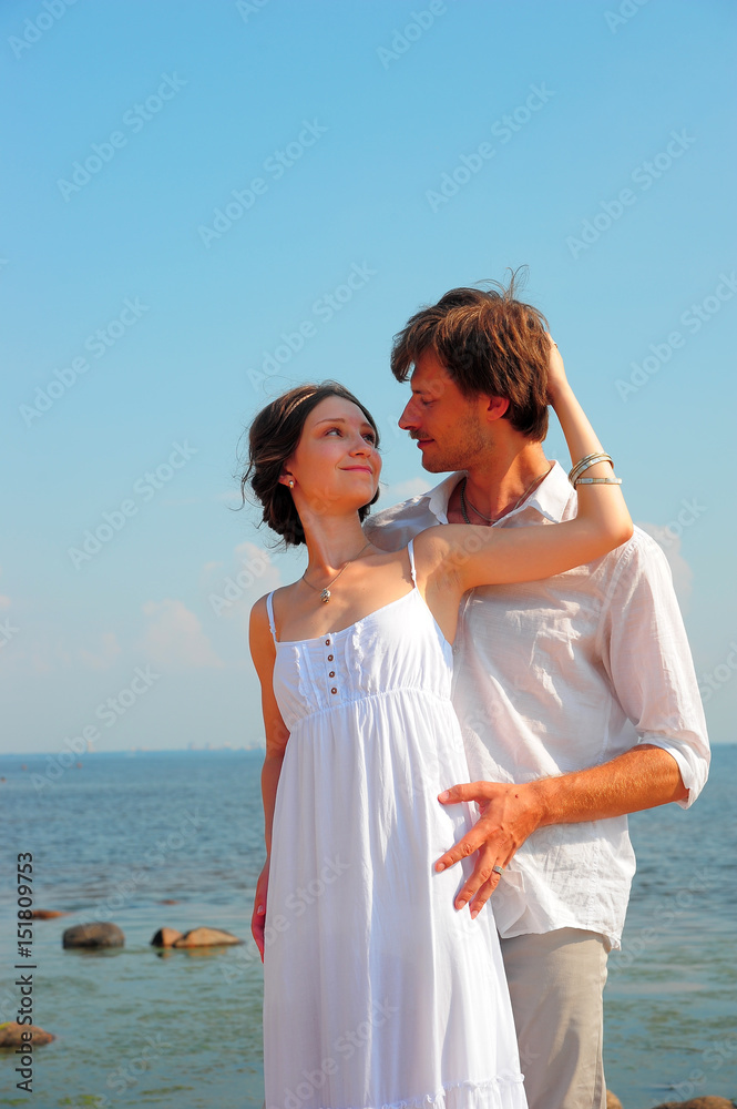 Young romantic couple in white on the seashore
