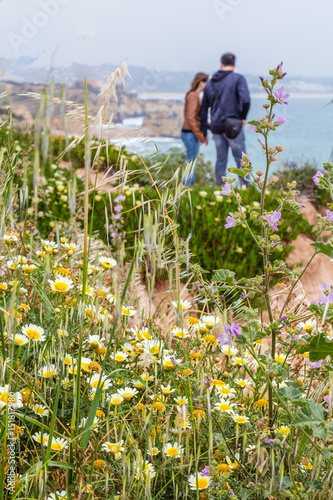 Young couple enjouing the view on Praia do Camilo, near Lagos, Algarve in Portugal photo