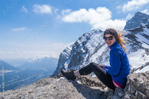 female hiker on top of mountain with sun glasses photo