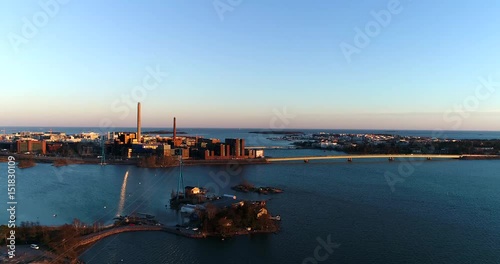 Seurasaarenselkä, Cinema 4k aerial view of a flight towards lapinlahden silta and ruoholahti factories, on a sunny spring evening, in Helsinki, Finland photo