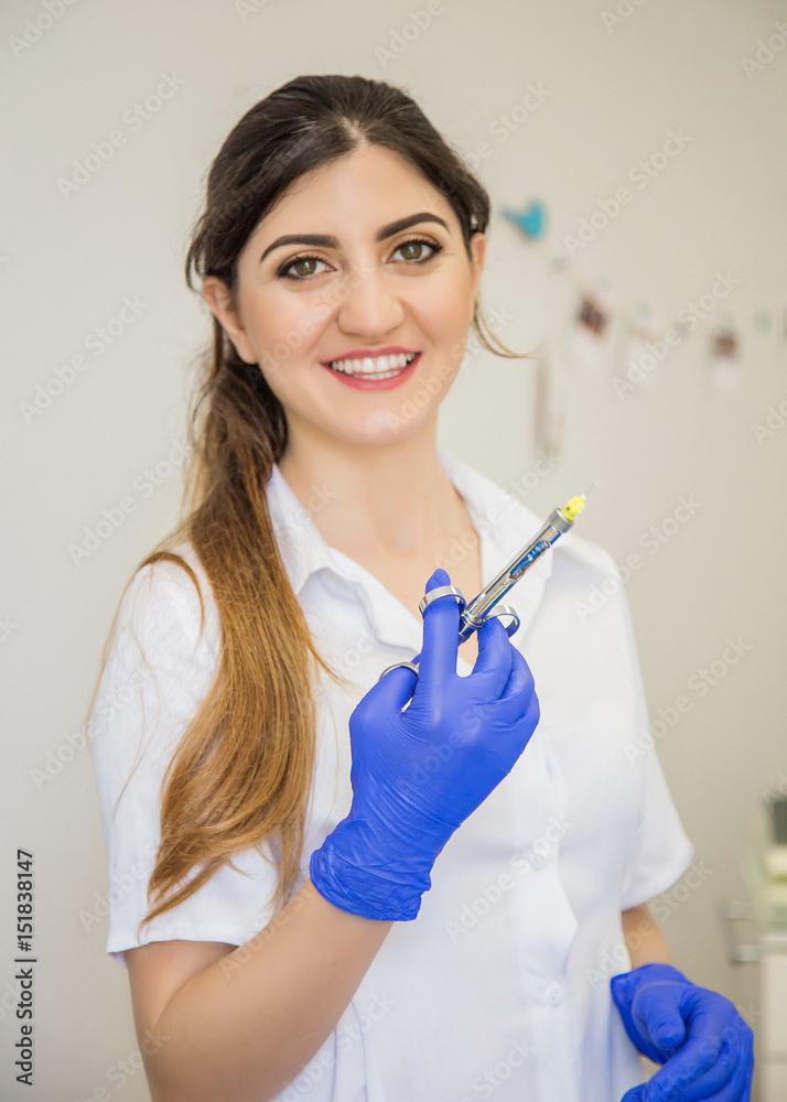 Beautiful doctor in blue gloves with anesthetic aspirating syringe. Dentist nurse. Cosmetology. Dentist prick. Dental tools Beautiful doctor in blue gloves with anesthetic aspirating syringe. Dentist nurse. Cosmetology. Dentist prick. Dental tools