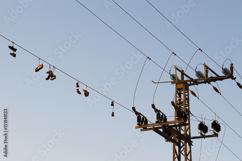 Shoes dangling on a electric cable over the street