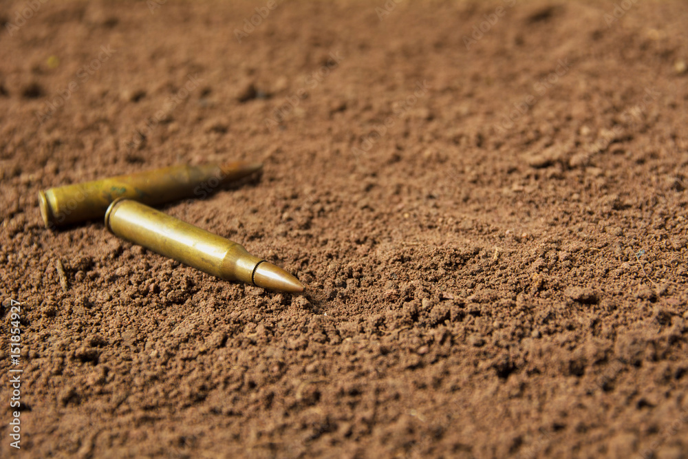 Two bullets, machine gun bullets on soil background Two bullets, machine gun bullets on soil background