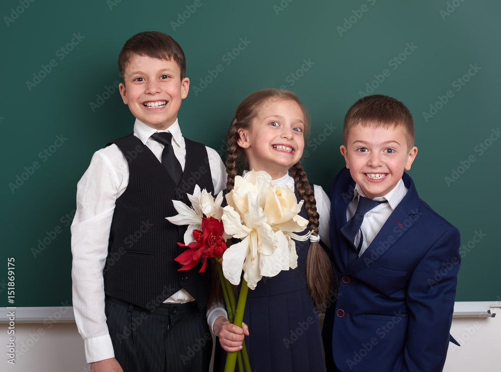 boys giving girl flowers, elementary school child near blank chalkboard background, dressed in classic black suit, group pupil, education concept boys giving girl flowers, elementary school child near blank chalkboard background, dressed in classic black suit, group pupil, education concept