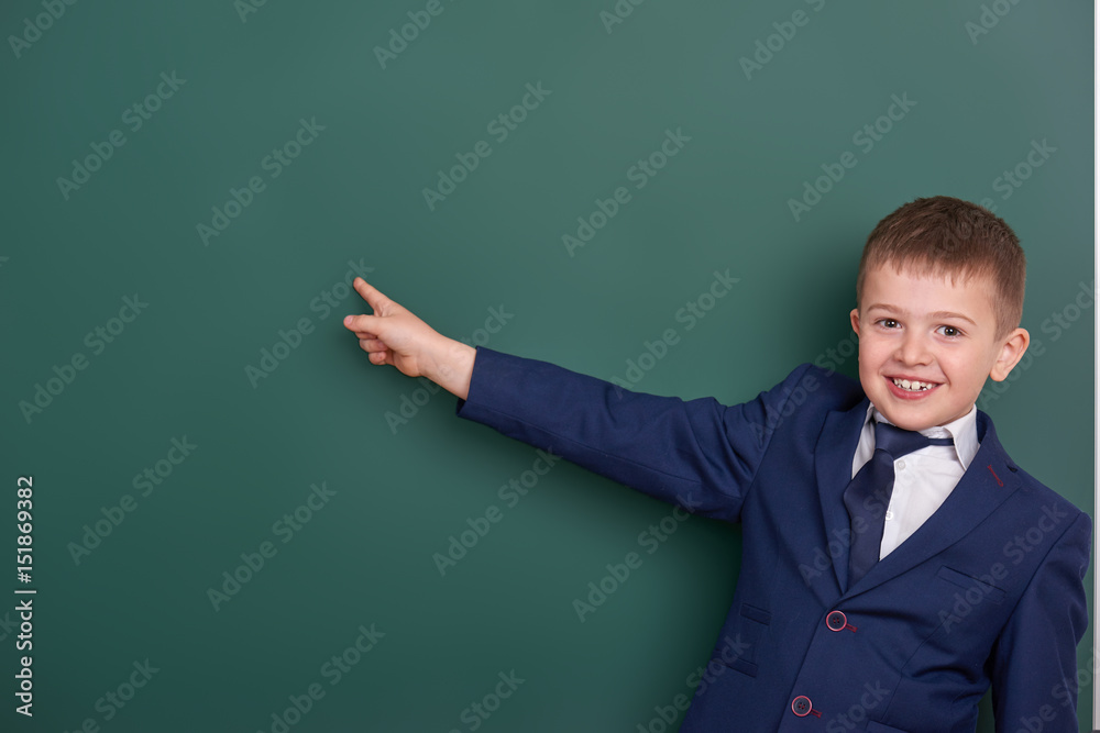 school boy point the finger near blank chalkboard background, dressed in classic black suit, group pupil, education concept school boy point the finger near blank chalkboard background, dressed in classic black suit, group pupil, education concept