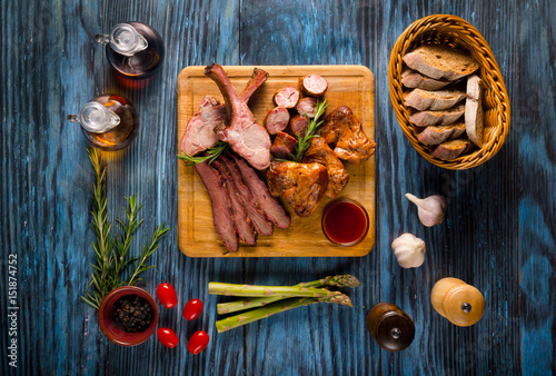 Assorted smoked meat on rustic wooden background