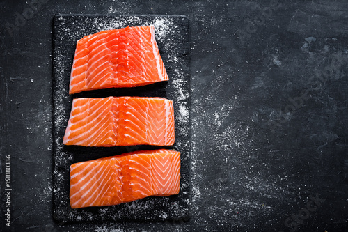 Raw salmon filet on dark slate background, wild atlantic fish photo