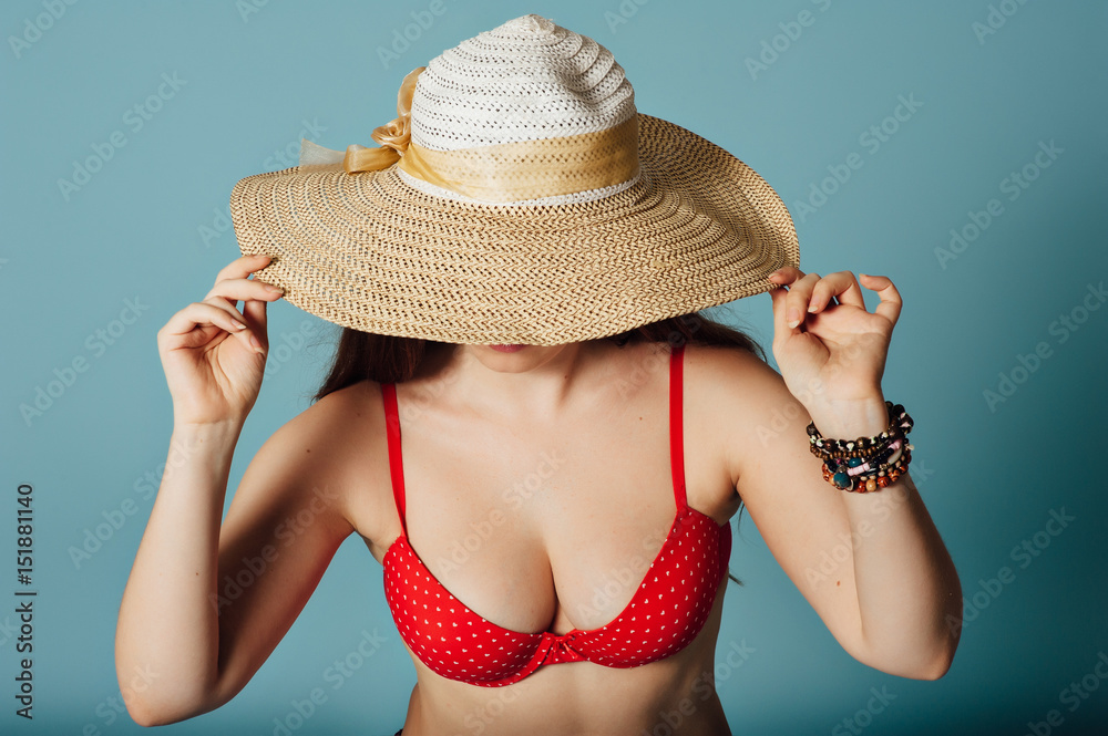 Summer girl covers her face with big hat Summer girl covers her face with big hat