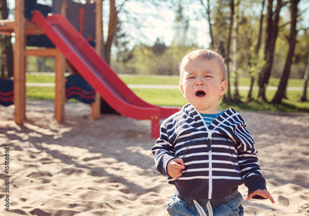 Little boy playing on playground and crying Little boy playing on playground and crying