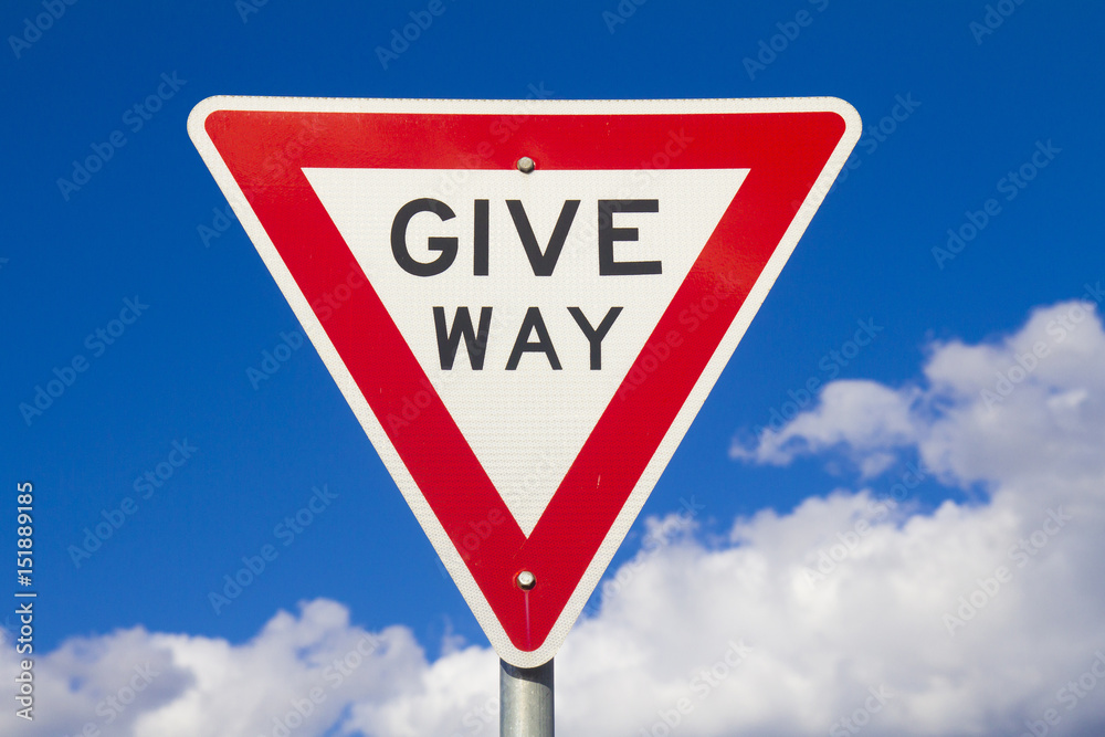 Give Way Sign Against A Blue Sky Give Way Sign Against A Blue Sky