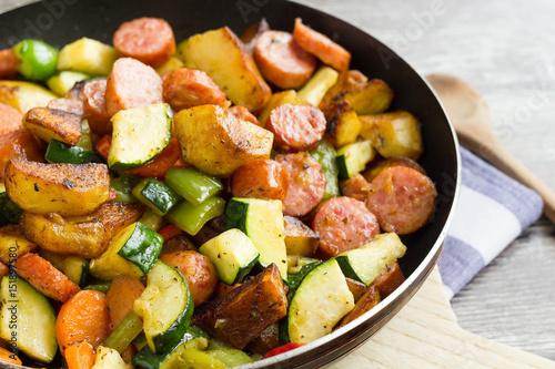 One pot sausage with colorful vegetables on cutting board