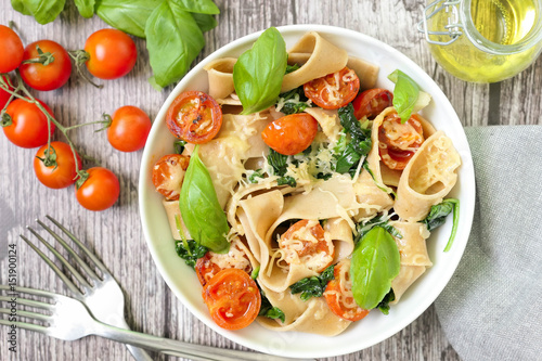 Whole wheat pasta with fresh basil and tomato, top view
