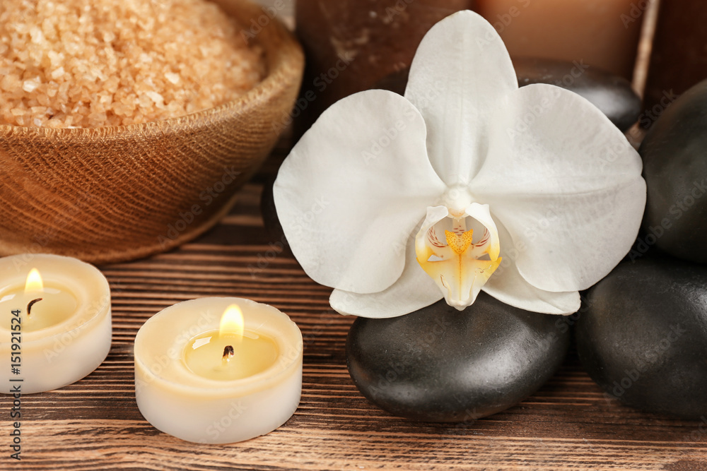 Spa stones with flower on wooden table Spa stones with flower on wooden table