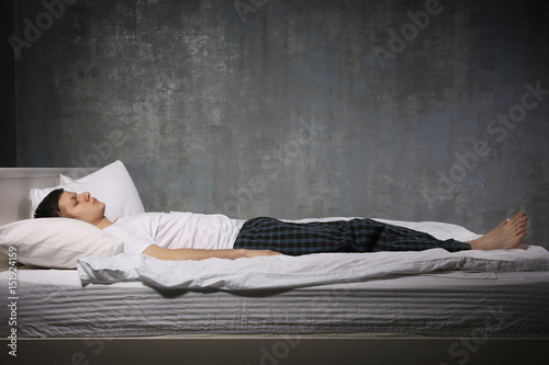 Young man sleeping in bed photo