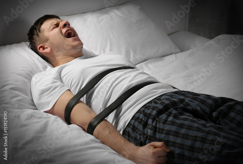 Young man tied up with belt...