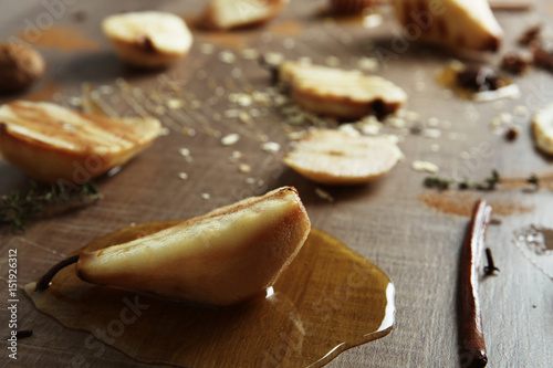 Tasty pears with honey sauce on wooden background