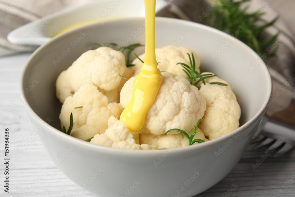 Bowl with cauliflower and cheese sauce on table, closeup Bowl with cauliflower and cheese sauce on table, closeup