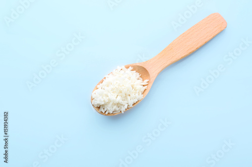Wooden spoon with coconut rice on blue background
