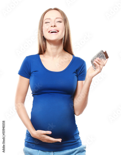 Young pregnant woman with chocolate on white background