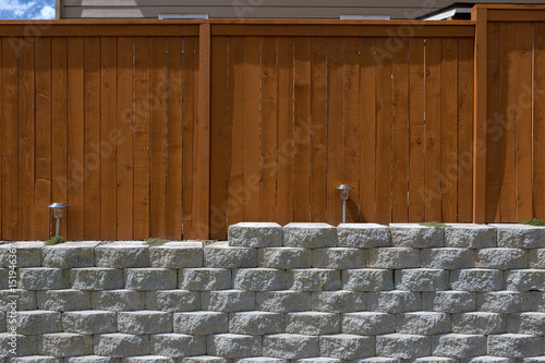Wood Fencing on Cement Stack Stone Retaining Wall photo