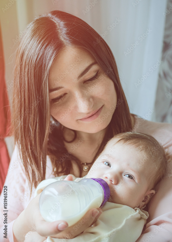 A young mother, feeding the child A young mother, feeding the child