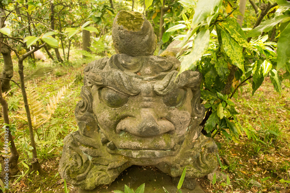 A stone statue in a garden A stone statue in a garden