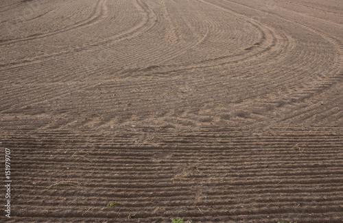 Plowed field. Drawing on the ground furrows and traces of tractor tires. Early Spring on Podlasie, Eastern Poland.