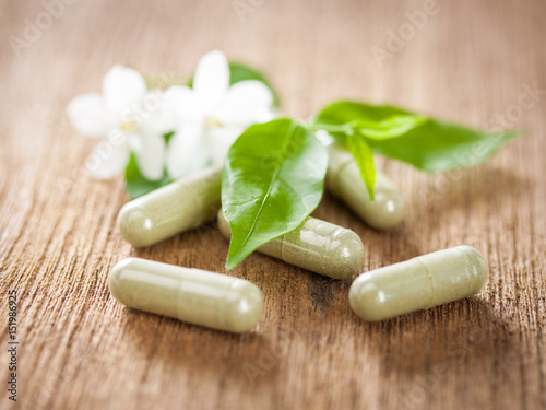 Herbal medicine made from paniculata on wooden background