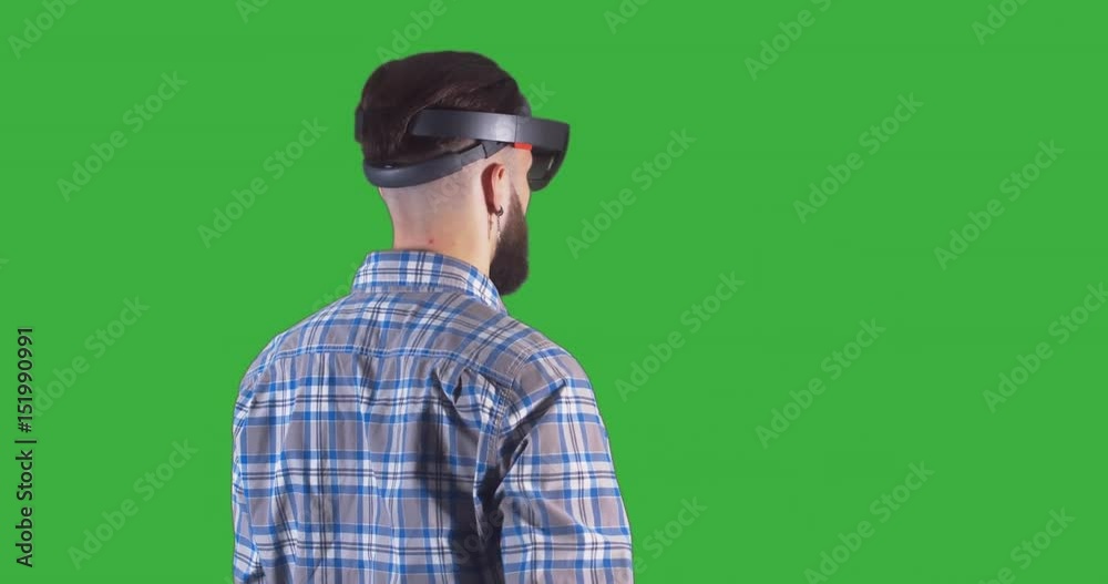 Young adult Caucasian male using holographic augmented reality glasses. Green screen chroma key. 4K UHD RAW edited footage