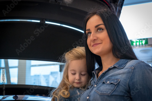 Girl and mom in exhibition hall for car