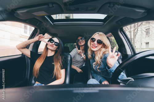 Three beautiful young cheerful women looking happy and playful while sitting in car © F8  \ Suport Ukraine