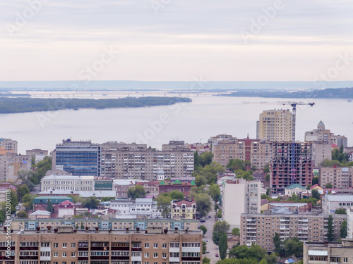 The city's skyline. The Russian province of Saratov. High-rise residential buildings, the Volga river and the railway bridge on the horizon