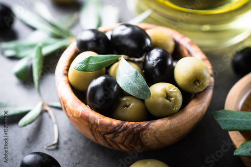 Black and green olives in wooden bowl