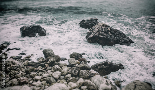 Wave and stone shore close-up. Beautiful abstract natural background and texture