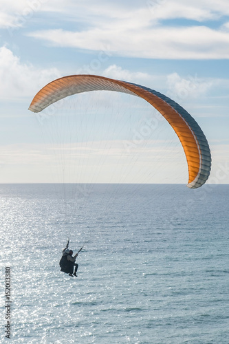 Flying tandem paraglider over the sea, vertical shot