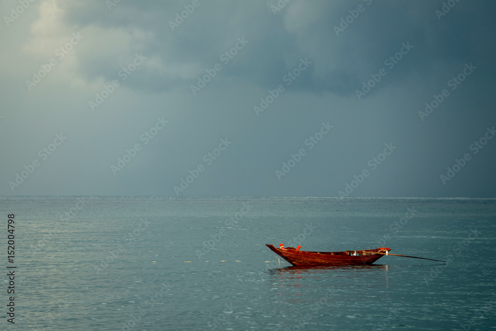 Red fishing boat with approaching storm