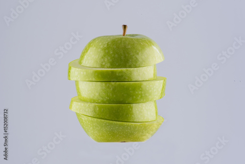 Green apple sliced in pieces, isolated on background. 