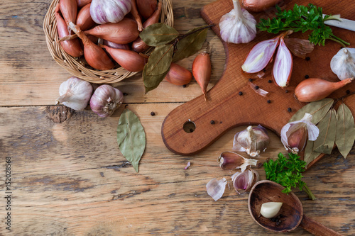 Scattered garlic and onion on a wooden background