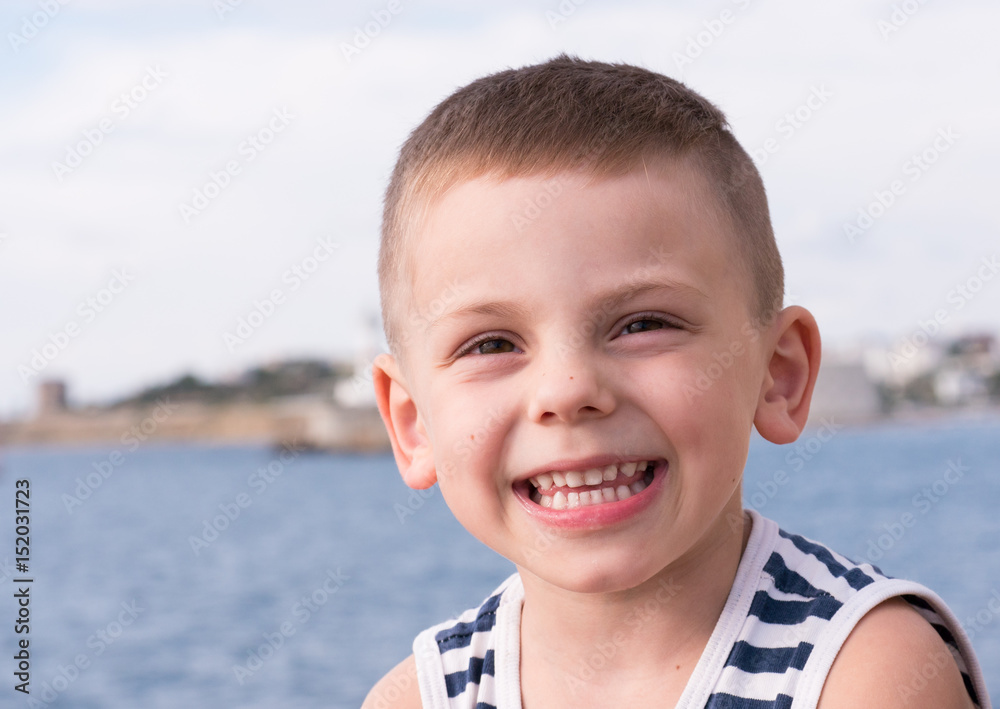 smiling little kid in sailor stripes singlet on sea background smiling little kid in sailor stripes singlet on sea background