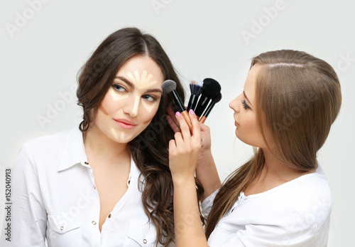 Contouring.Make up woman face. Contour and highlight makeup.Applying Make-up. Woman with a brush for make-up