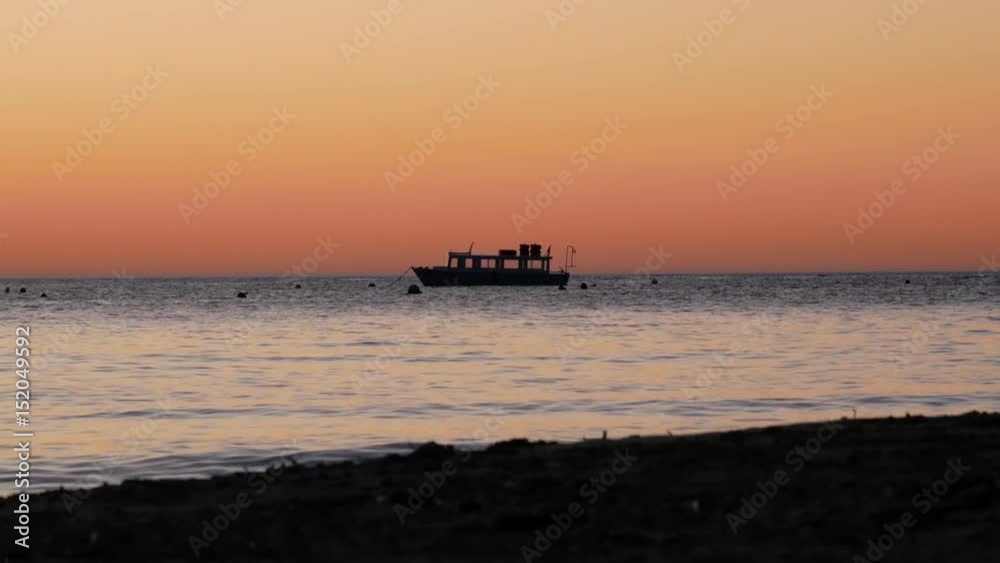 Lonely boat rocking on the ocean at sunset Lonely boat rocking on the ocean at sunset