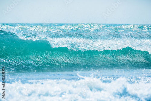 Blue wave in tropical ocean. Wave barrel crashing and sun light