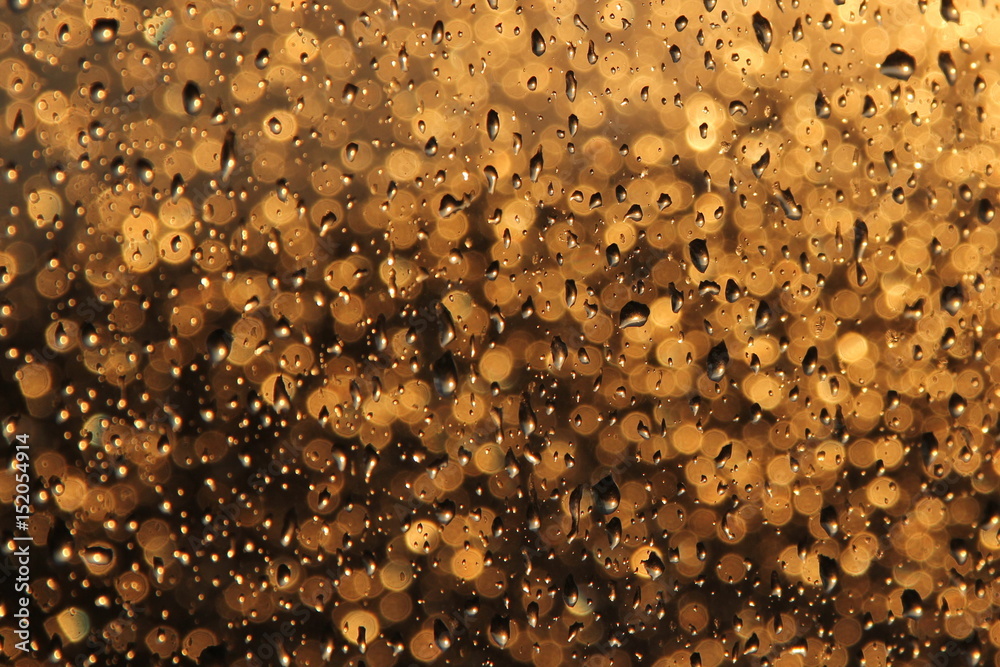 Raindrops on the window on sunset background
