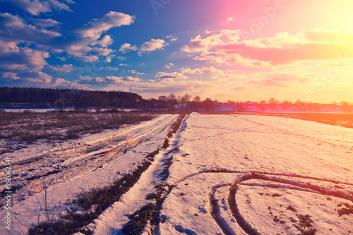 Snowy field in winter at sunset