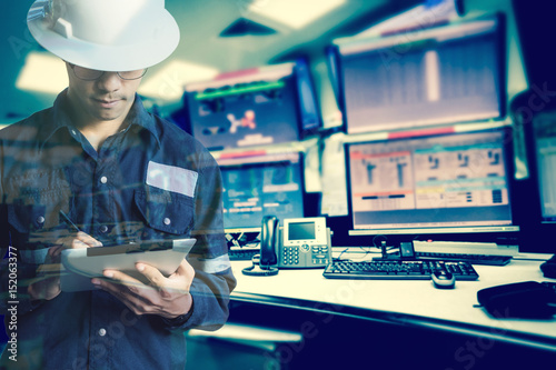 Double exposure of  Engineer or Technician man in working shirt  working with tablet in control room of oil and gas platform or plant industrial for monitor process, business and industry concept