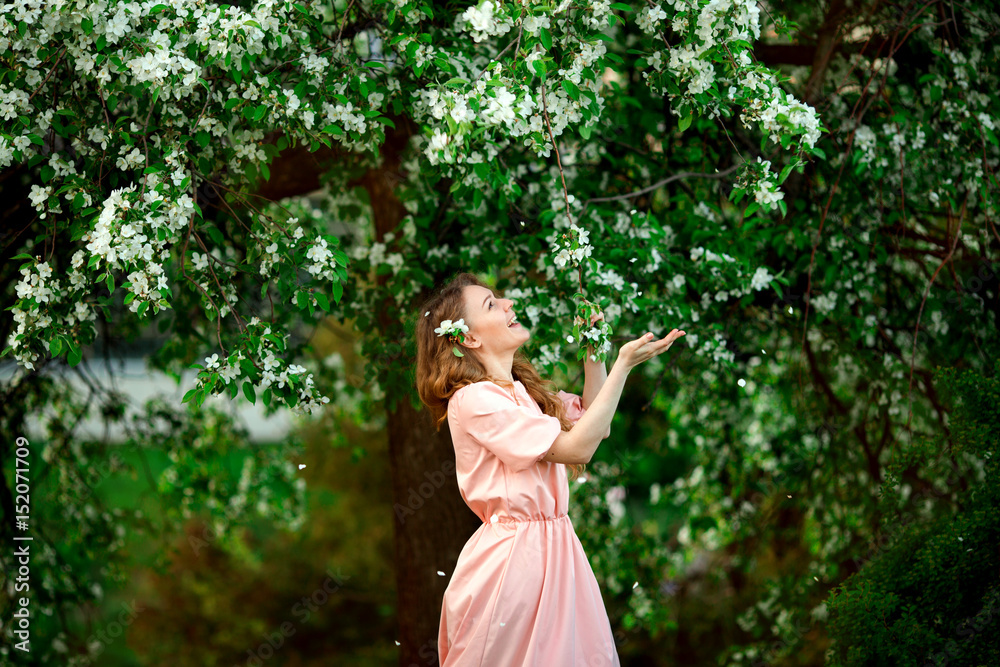 Beautiful girl in the blossoming spring tree
