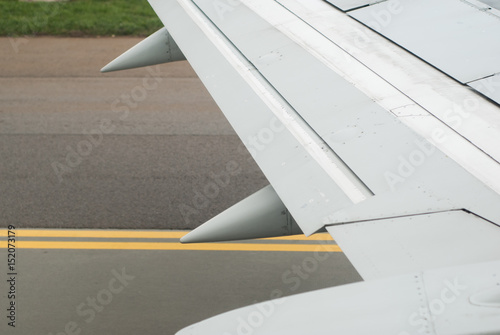 Wing of plane close up on the background of the tarmac 